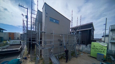 足場に囲まれ外装工事が進む住宅